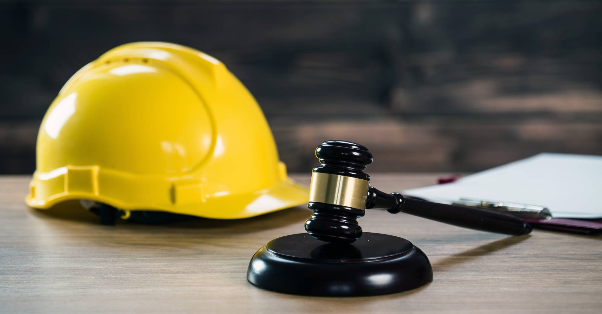 Casco da cantiere accanto al martelletto del giudice, sul banco di legno