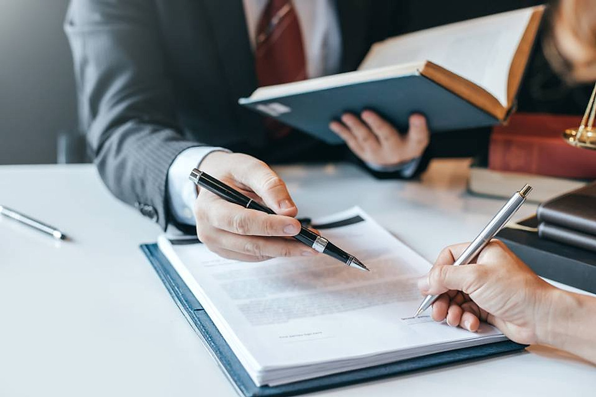 Firma di un atto con la penna stilografica, sopra il fascicolo aperto